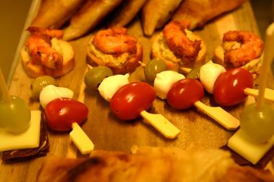 Plateau de bouchées apéritives variées comprenant samoussas, brochettes de légumes et crevettes sur toasts.