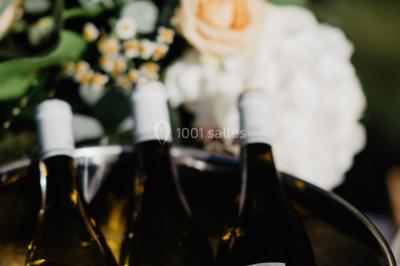 Rangées de tonneaux en bois alignés dans une cave voûtée avec éclairage tamisé.