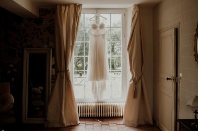 Rangées de tonneaux en bois alignés dans une cave voûtée avec éclairage tamisé.