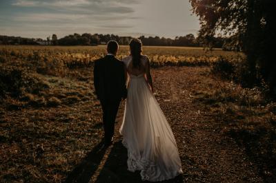 Rangées de tonneaux en bois alignés dans une cave voûtée avec éclairage tamisé.