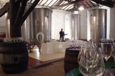 Rangées de tonneaux en bois alignés dans une cave voûtée avec éclairage tamisé.