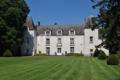 Rangées de tonneaux en bois alignés dans une cave voûtée avec éclairage tamisé.