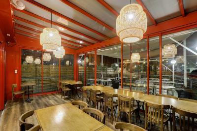 Terrasse extérieure avec tables et chaises en métal, éclairée la nuit, protégée par des toiles tendues.