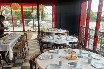 Terrasse extérieure avec tables et chaises en métal, éclairée la nuit, protégée par des toiles tendues.