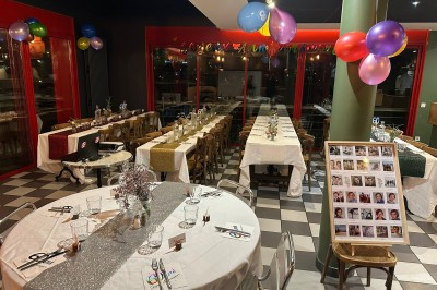 Coucher de soleil vibrant avec des nuages colorés se reflétant sur une rivière bordée d'arbres et de bâtiments.