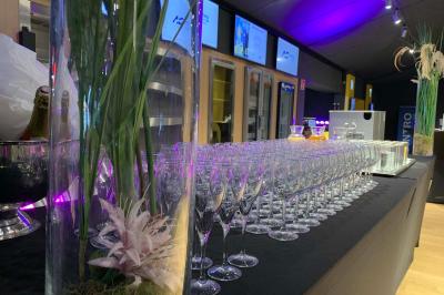 Espace intérieur avec tables hautes noires, distributeur automatique et éclairage tamisé dans un cadre moderne.