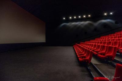 Espace intérieur avec tables hautes noires, distributeur automatique et éclairage tamisé dans un cadre moderne.