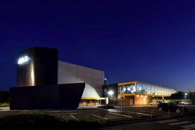 Espace intérieur avec tables hautes noires, distributeur automatique et éclairage tamisé dans un cadre moderne.