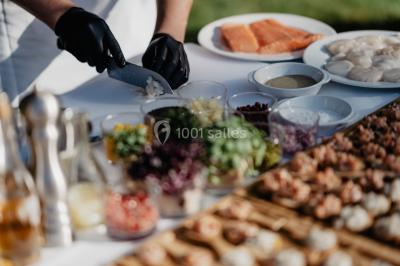 Chambre lumineuse avec lit double, fauteuils, cheminée, meubles anciens et mur décoré de motifs floraux.