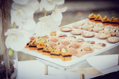 Chambre lumineuse avec lit double, fauteuils, cheminée, meubles anciens et mur décoré de motifs floraux.