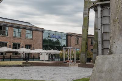 Miniature Location salle Maasmechelen (Limbourg) - Pathé Genk #16 Façade vitrée d'un bâtiment industriel rénové avec une ancienne structure minière visible en arrière-plan.