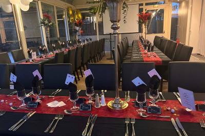 Lit double avec draps blancs, couverture bleue et coussins décoratifs, encadré par deux lampes murales allumées.