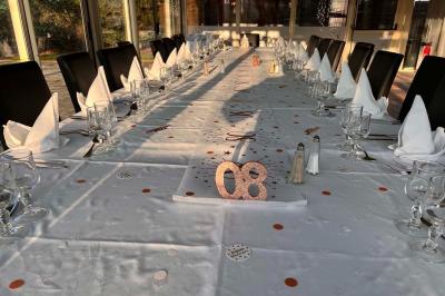 Lit double avec draps blancs, couverture bleue et coussins décoratifs, encadré par deux lampes murales allumées.