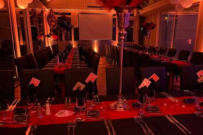 Lit double avec draps blancs, couverture bleue et coussins décoratifs, encadré par deux lampes murales allumées.