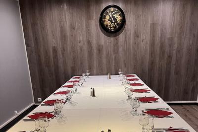 Lit double avec draps blancs, couverture bleue et coussins décoratifs, encadré par deux lampes murales allumées.