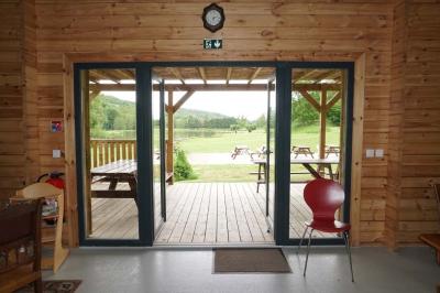 Salle décorée pour un repas festif, avec tables dressées, nappes blanches et touches de tissu coloré.