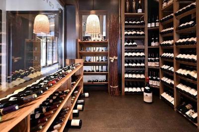 Chambre d'hôtel avec lit double, bureau en bois, lampe suspendue, fenêtre et décoration murale rouge et beige.