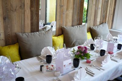 Chambre d'hôtel avec lit double, bureau en bois, lampe suspendue, fenêtre et décoration murale rouge et beige.