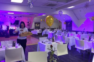 Chambre d'hôtel avec lit double, bureau en bois, lampe suspendue, fenêtre et décoration murale rouge et beige.