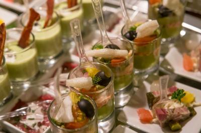 Chambre d'hôtel avec lit double, bureau en bois, lampe suspendue, fenêtre et décoration murale rouge et beige.