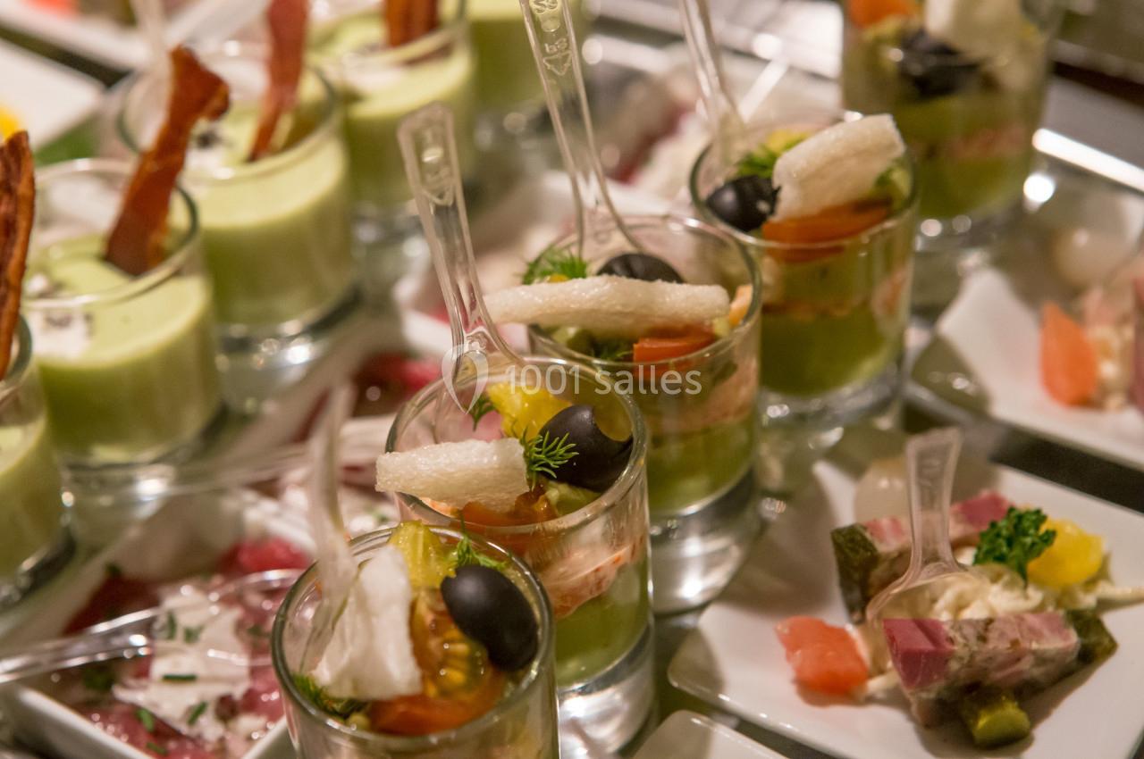 Verrines variées avec légumes, olives, et garnitures, présentées sur un plateau lors d'un buffet.