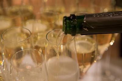 Chambre d'hôtel avec lit double, bureau en bois, lampe suspendue, fenêtre et décoration murale rouge et beige.