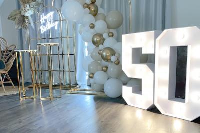 Chambre d'hôtel avec lit double, bureau en bois, lampe suspendue, fenêtre et décoration murale rouge et beige.