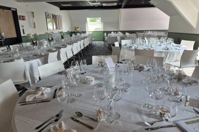 Chambre d'hôtel avec lit double, bureau en bois, lampe suspendue, fenêtre et décoration murale rouge et beige.
