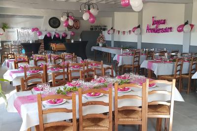 Bâtiments en colombages et en briques avec toiture en ardoise, entourés de végétation sous un ciel partiellement nuageux.