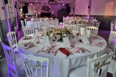 Bâtiments en colombages et en briques avec toiture en ardoise, entourés de végétation sous un ciel partiellement nuageux.