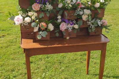 Bâtiments en colombages et en briques avec toiture en ardoise, entourés de végétation sous un ciel partiellement nuageux.