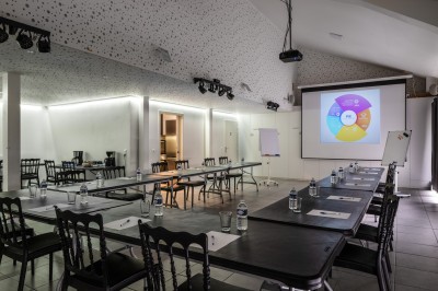 Table avec cafetières, tasses bleues empilées et panier de viennoiseries, dans un espace de pause.