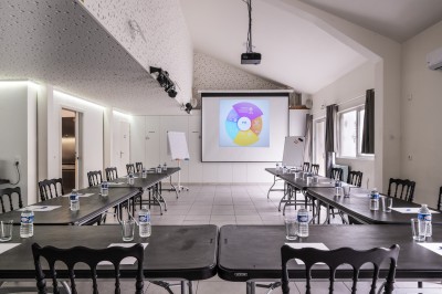 Table avec cafetières, tasses bleues empilées et panier de viennoiseries, dans un espace de pause.