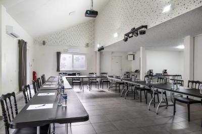 Table avec cafetières, tasses bleues empilées et panier de viennoiseries, dans un espace de pause.
