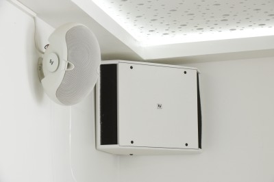 Table avec cafetières, tasses bleues empilées et panier de viennoiseries, dans un espace de pause.