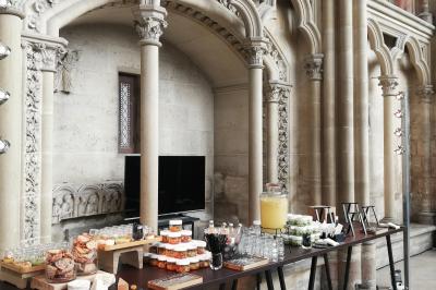 Buffet dressé dans une grande salle avec structure métallique, proposant boissons, viennoiseries et plats variés.
