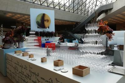 Buffet dressé dans une grande salle avec structure métallique, proposant boissons, viennoiseries et plats variés.