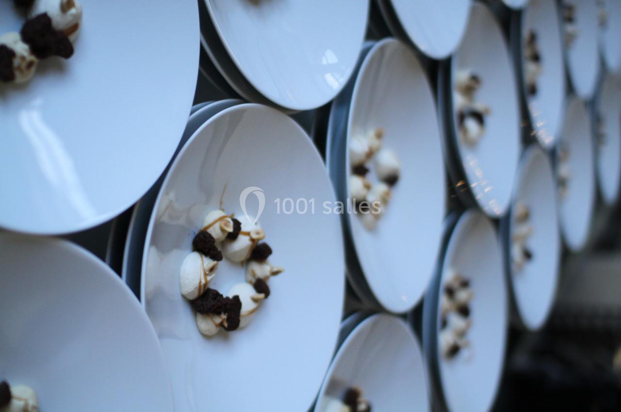 Assiettes blanches alignées, chacune contenant une présentation artistique de petites portions de nourriture.