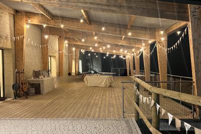 Chambre lumineuse sous les combles avec quatre lits simples, poutres apparentes et fenêtre de toit.