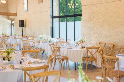 Chambre lumineuse sous les combles avec quatre lits simples, poutres apparentes et fenêtre de toit.
