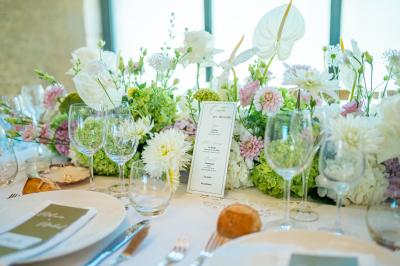 Chambre lumineuse sous les combles avec quatre lits simples, poutres apparentes et fenêtre de toit.