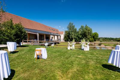 Chambre lumineuse sous les combles avec quatre lits simples, poutres apparentes et fenêtre de toit.