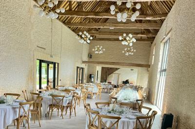 Chambre lumineuse sous les combles avec quatre lits simples, poutres apparentes et fenêtre de toit.