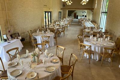 Chambre lumineuse sous les combles avec quatre lits simples, poutres apparentes et fenêtre de toit.