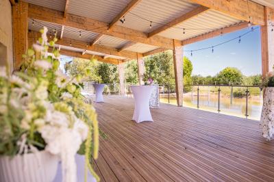 Chambre lumineuse sous les combles avec quatre lits simples, poutres apparentes et fenêtre de toit.