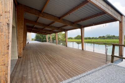 Chambre lumineuse sous les combles avec quatre lits simples, poutres apparentes et fenêtre de toit.