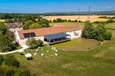 Chambre lumineuse sous les combles avec quatre lits simples, poutres apparentes et fenêtre de toit.