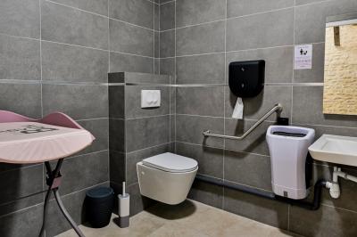 Chambre lumineuse sous les combles avec quatre lits simples, poutres apparentes et fenêtre de toit.