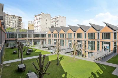 Un technicien supervise un enregistrement en studio, avec trois personnes chantant derrière une vitre insonorisée.