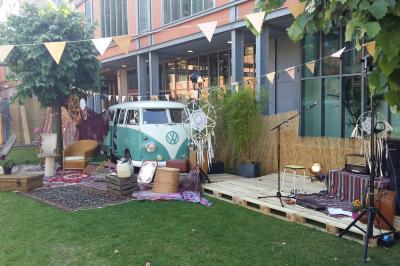 Un technicien supervise un enregistrement en studio, avec trois personnes chantant derrière une vitre insonorisée.